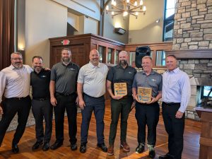 Ben Bailey, Andy Wasilewski, Mark Peterson, Jeremy Rodenbostel, Dan Reasoner, Jeff Michael, and Steve Carlson posing for a photo.